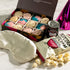 A curated gift set featuring a box of twelve assorted macarons, a can of Clover Club cocktail, a cream satin sleep mask, and gourmet popcorn. The perfect addition to a sleepover night.
