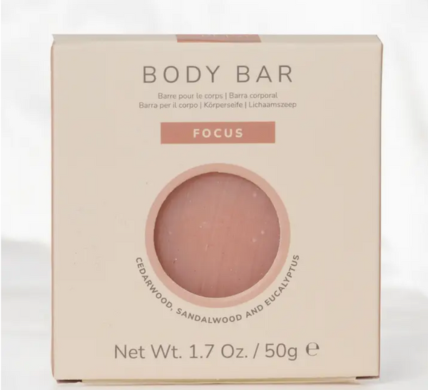 A square beige box for a pinkish body bar product labeled 'BODY BAR' and 'FOCUS', with the blended aroma of Cedarwood, Sandalwood and Eucalyptus. Part of the Relaxation Macaron Gift Set.