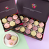 Open Mother’s Day macaron gift boxes showcasing peach & elderflower, raspberry & basil and dark chocolate rose macarons with floral icing decorations.