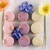 Mother’s Day macarons in peach & elderflower, raspberry & basil, and dark chocolate rose, decorated with delicate royal icing flowers and styled with fresh spring blooms on marble.