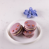 Raspberry & basil macarons with light purple shells and pink royal icing flower decorations, created for Mother’s Day gifting